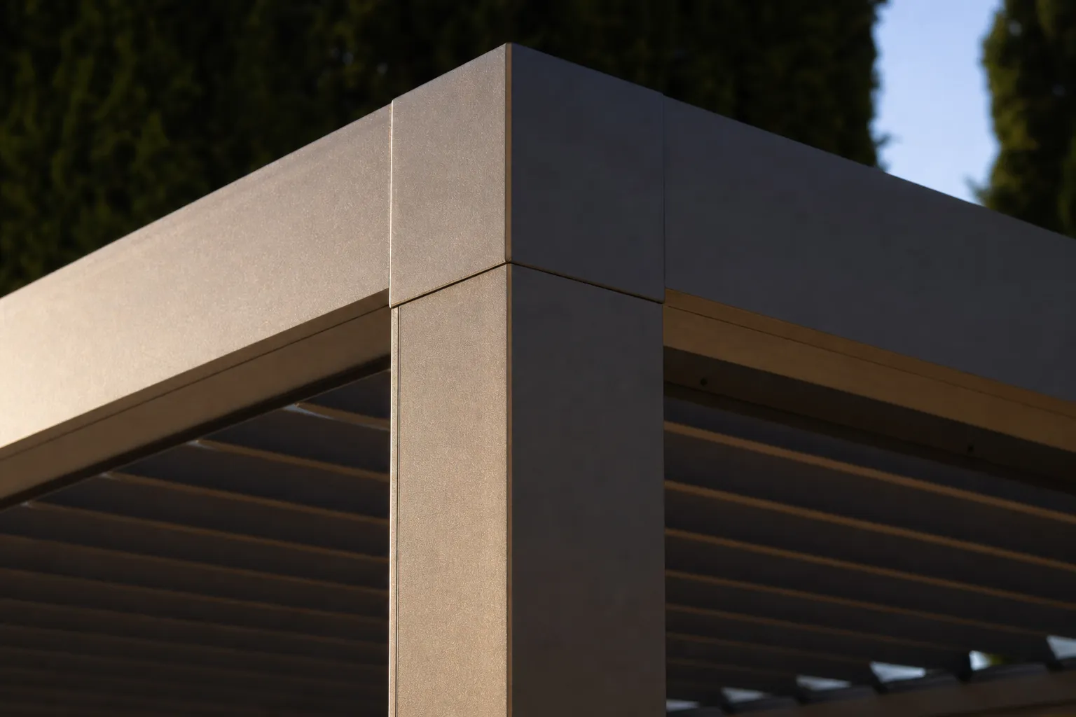 Gros plan sur un profil aluminium de pergola ton bronze champagne, lumière rasante