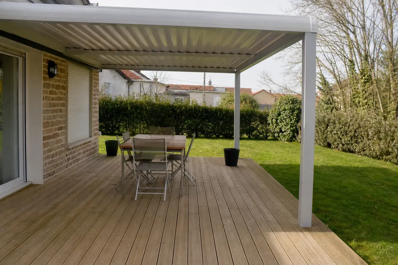 Terrasse en bois d’un pavillon avec jardin clos, pergola aluminium claire, quartier pavillonnaire calme